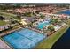 Aerial view of the community pool and tennis courts alongside a placid lake surrounded by homes at 2919 Banana Palm Dr, Kissimmee, FL 34747