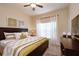 Cozy bedroom featuring a ceiling fan, dresser and a sunlit window with white curtains at 2919 Banana Palm Dr, Kissimmee, FL 34747