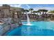 Sparkling community pool with a cascading waterfall feature surrounded by lush landscaping at 2919 Banana Palm Dr, Kissimmee, FL 34747