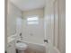 An all white bathroom features a tub and shower combination, and a toilet at 3025 Bon Air Dr, Orlando, FL 32818