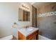 Close-up of renovated bathroom with modern vanity, mirror, and tiled shower at 3025 Bon Air Dr, Orlando, FL 32818
