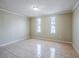 Bright bedroom featuring tile flooring, neutral walls, and natural light from dual windows at 3025 Bon Air Dr, Orlando, FL 32818