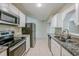Updated kitchen features white cabinetry, granite countertops, and stainless-steel appliances at 3025 Bon Air Dr, Orlando, FL 32818