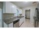 Well-lit kitchen featuring white cabinets, granite countertops, and stainless-steel appliances at 3025 Bon Air Dr, Orlando, FL 32818