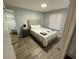 Comfortable bedroom with light gray walls, hardwood floors, and a full-length mirror at 3147 Britannia Blvd # A, Kissimmee, FL 34747