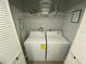A laundry room featuring a white washer and dryer with shelving and an ironing board at 3147 Britannia Blvd # A, Kissimmee, FL 34747