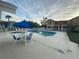 Community pool with lounge chairs, tables, and a blue umbrella at 3147 Britannia Blvd # A, Kissimmee, FL 34747