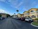 Street view of colorful condos with a parking lot and palm trees at 3147 Britannia Blvd # A, Kissimmee, FL 34747