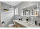 Modern bathroom featuring a gray wall, floating shelves, stylish fixtures, and an illuminated mirror at 320 Lakeview St # 214, Orlando, FL 32804