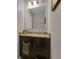 Half-bath featuring a dark wood vanity, granite countertop and accent mirror at 320 Primrose Dr, Davenport, FL 33837