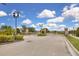 Gated entrance to the community, featuring stone pillars, lush landscaping, and secure access control at 320 Primrose Dr, Davenport, FL 33837