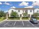 Inviting townhome showcasing manicured landscaping, parking, and a cozy entrance, set against a bright, cloudy sky at 320 Primrose Dr, Davenport, FL 33837