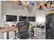 Well-organized home office with modern adjustable desk, multiple monitors, and ample shelf storage at 320 Primrose Dr, Davenport, FL 33837