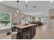 Kitchen island features dark wood cabinets and granite countertops, open to the living space at 320 Primrose Dr, Davenport, FL 33837