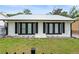 Charming home featuring black shutters, a metal roof and well-manicured front yard at 335 Debary Ave, Debary, FL 32713