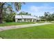 Well-maintained home featuring a lush front lawn and a charming driveway at 335 Debary Ave, Debary, FL 32713