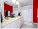 Bathroom features a dual sink vanity, shower-tub combo, and red accent wall at 3567 Shallot Dr # 103, Orlando, FL 32835