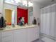 Bathroom features a dual sink vanity, shower-tub combo, and red accent wall at 3567 Shallot Dr # 103, Orlando, FL 32835