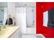 Bathroom features a dual sink vanity, shower-tub combo, and red accent wall at 3567 Shallot Dr # 103, Orlando, FL 32835