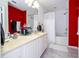 Bathroom features a dual sink vanity, shower-tub combo, and red accent wall at 3567 Shallot Dr # 103, Orlando, FL 32835