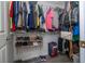 Walk-in closet with hanging clothes, shelving for shoes, and suitcase at 3567 Shallot Dr # 103, Orlando, FL 32835