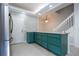 A well lit kitchen with teal cabinets, an island, and stainless steel appliances at 3567 Shallot Dr # 103, Orlando, FL 32835