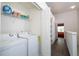 Hallway laundry closet features washer, dryer and storage shelving with supplies at 3567 Shallot Dr # 103, Orlando, FL 32835