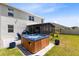 Backyard patio featuring a hot tub, screened lanai, outdoor seating, and lush landscaping for relaxation and entertainment at 3829 Allegany Ln, Sanford, FL 32771