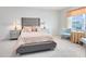 Inviting bedroom features a tufted headboard, soft carpet, and stylish decor, complemented by natural light at 3829 Allegany Ln, Sanford, FL 32771