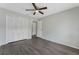 This bedroom features wood-look floors, neutral paint, a ceiling fan and a closet with bi-fold doors at 4136 Pershing Pointe Pl # 2, Orlando, FL 32822