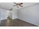 This bedroom features wood-look flooring, neutral paint, a ceiling fan, and a door to the bathroom at 4136 Pershing Pointe Pl # 2, Orlando, FL 32822