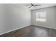 This bedroom features wood-look flooring, neutral paint, a ceiling fan, and a window with blinds at 4136 Pershing Pointe Pl # 2, Orlando, FL 32822