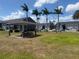 Community pavilion with picnic tables, set in a grassy area with palm trees and apartment buildings at 4136 Pershing Pointe Pl # 2, Orlando, FL 32822