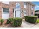 Exterior view of a brick building with a white door, lanterns, and manicured bushes at 4332 Lake Underhill Rd # 12D10, Orlando, FL 32803