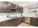 Modern kitchen with marble countertops, stainless steel appliances, and sleek wood cabinets at 4332 Lake Underhill Rd # 12D10, Orlando, FL 32803