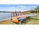Picturesque lake view with a wooden dock, colorful kayaks, and tranquil water scenery at 4332 Lake Underhill Rd # 12D10, Orlando, FL 32803