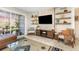 Well-lit living room featuring a large TV, stylish shelving, and a comfortable seating arrangement at 4332 Lake Underhill Rd # 12D10, Orlando, FL 32803
