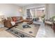 Bright living room with a leather sectional, marble floors, and sliding glass doors leading to the patio at 4332 Lake Underhill Rd # 12D10, Orlando, FL 32803