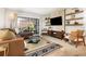 Sunlit living room with a large sliding glass door, plush leather sofa, and stylish decor at 4332 Lake Underhill Rd # 12D10, Orlando, FL 32803