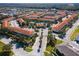 Aerial view of a resort community with red roofs, pool, and gated entrance at 4725 Coral Castle Dr, Kissimmee, FL 34746