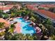Aerial view of community pool and surrounding townhomes with red roofs at 4725 Coral Castle Dr, Kissimmee, FL 34746