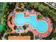 Overhead view of a uniquely shaped pool surrounded by lounge chairs and beautiful foliage at 4725 Coral Castle Dr, Kissimmee, FL 34746
