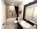 Bathroom featuring a tiled shower-tub, granite countertop, dark wood cabinets, and framed mirror at 5114 Hawkstone Dr, Sanford, FL 32771