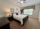 Serene bedroom with a large window, providing natural light, complemented by dark wood furniture and neutral tones at 5114 Hawkstone Dr, Sanford, FL 32771