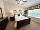 Bright bedroom with a large window, offering natural light, complemented by dark wood furniture and neutral tones at 5114 Hawkstone Dr, Sanford, FL 32771