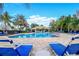 Resort-style community pool with lounge chairs, palm trees, and a sunny blue sky at 5114 Hawkstone Dr, Sanford, FL 32771