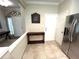 Open entryway with tile floors featuring stainless steel refrigerator and small table, leading to other rooms at 5114 Hawkstone Dr, Sanford, FL 32771
