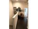 Upstairs hallway features dark hardwood floors, chair and decorative tree at 5114 Hawkstone Dr, Sanford, FL 32771