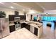 Bright and open kitchen featuring dark wood cabinets, granite counters, and seamless flow into the living room at 5114 Hawkstone Dr, Sanford, FL 32771