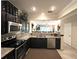 Modern kitchen with stainless appliances and granite countertops that open to the living area at 5114 Hawkstone Dr, Sanford, FL 32771